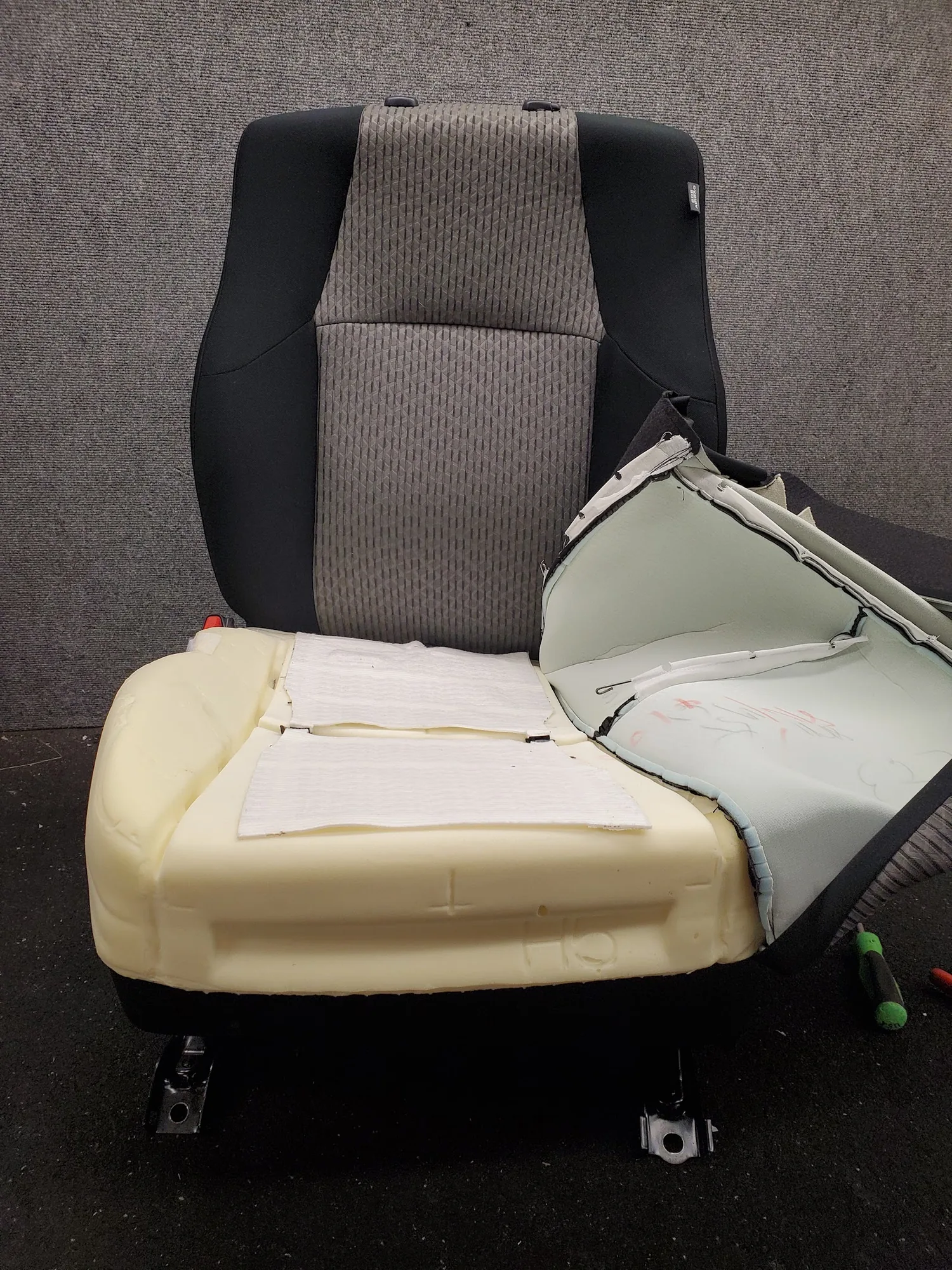 Almohadilla de calefacción siendo reemplazada en el cojín de un asiento